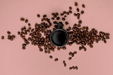 coffee beans and espresso mug on a pink background