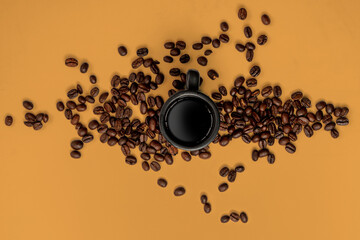 coffee beans and espresso mug on a orange background