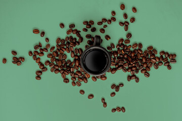 coffee beans and espresso mug on a green background