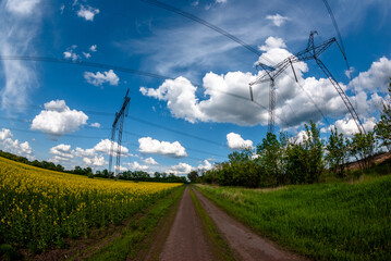 landscape with a power lines with blue clouds and road in the field . Power station lines 