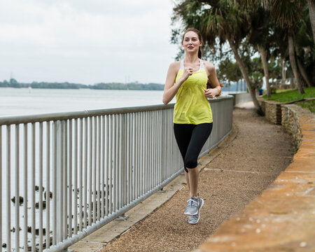 United States, Florida, Tampa, Woman jogging on footpath by river