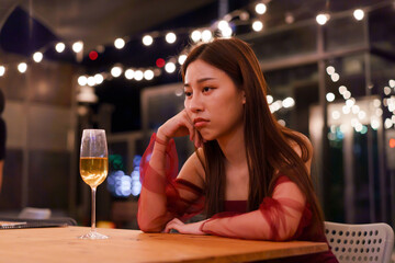 Young Asian woman feeling sad and heartbroken after breaking up with her boyfriend while sitting at restaurant - 491336199