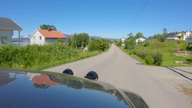 Hood view driving car through Norwegian village with narrow highway, Northern Norway, Slow motion 60p