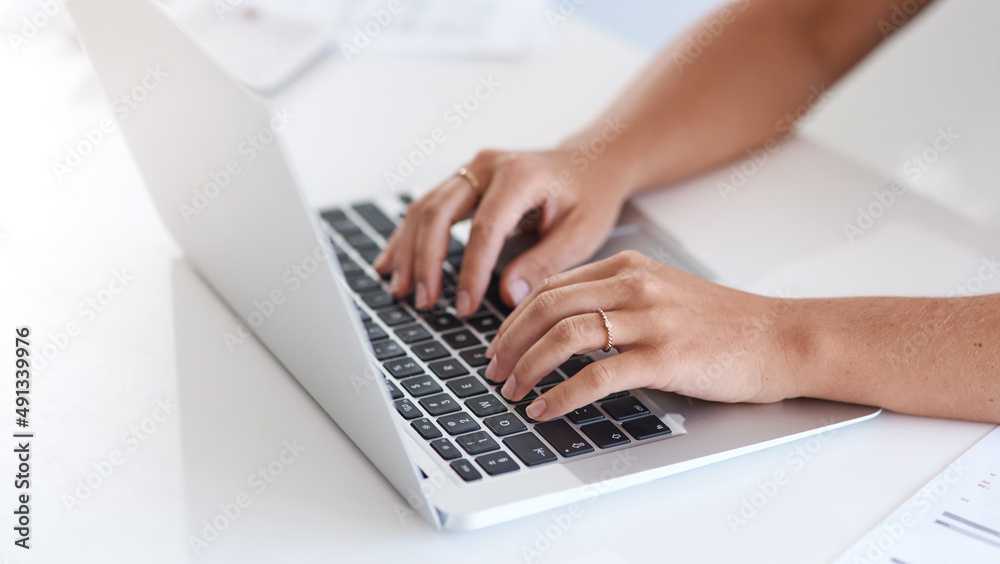 Poster staying responsive via email. closeup shot fo an unrecognisable businesswoman using a laptop in an o