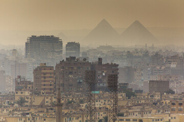 View of misty Cairo skyline with pyramids in the background, Egypt