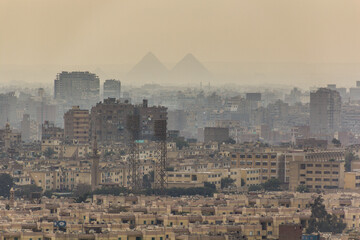 View of misty Cairo skyline with pyramids in the background, Egypt