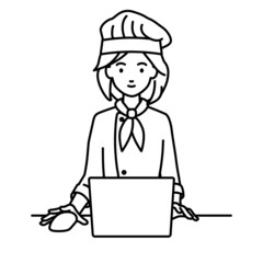 デスクで座ってPCを使っている調理師の女性