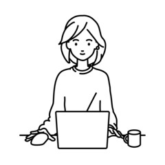 デスクで座ってPCを使っているリモートワークの女性