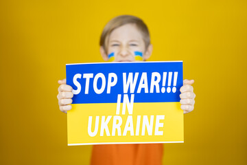 the boy stretched out a poster in front of him with the inscription stop the war in Ukraine