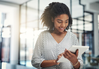 Pushing business further the smart way. Shot of a young businesswoman using a digital tablet in an office.