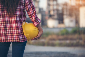 Refinery woman worker oil petro industry hand hold yellow worker helmet hard hat. Woman worker...