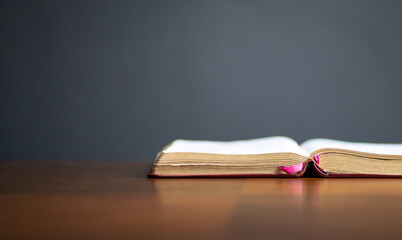 Open Holy Bible on wood table, with copy space.
