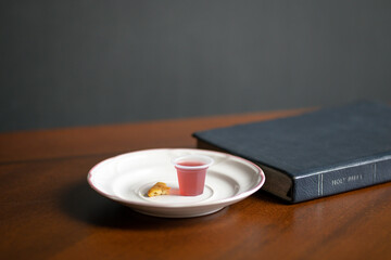 Christian Holy Communion sacraments, wine and bread with Holy Bible, on a wood table. Copy space.