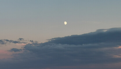 Luna del pomeriggio sopra le nuvole