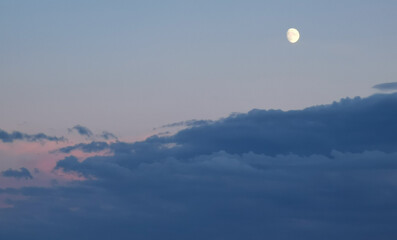 Luna del pomeriggio sopra le nuvole