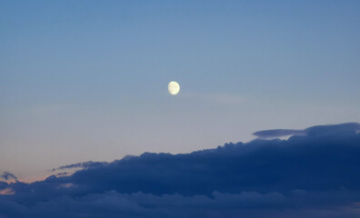 Luna del pomeriggio sopra le nuvole