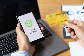Male hands holding phone with online payment screen and credit card in office. online shopping concept.
