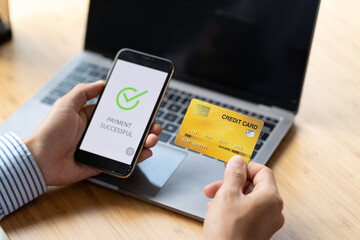 Male hands holding phone with online payment screen and credit card in office. online shopping concept.