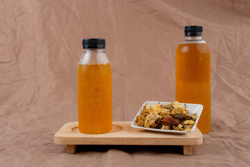 cold water of chrysanthemum flowers and dried chrysanthemum flowers on brown background. 