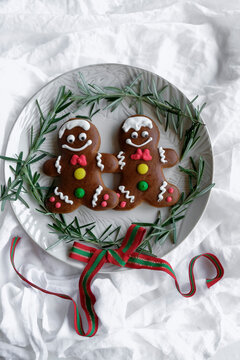 Decorative home baked festive pastries. Dark Chocolate Gingerbread Man with Decorations and Rosemary Herbs. Children favorite  Christmas cookies.