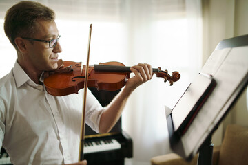 Scene of violin teacher teaching students by tablet for online lesson, Alternative education learn...