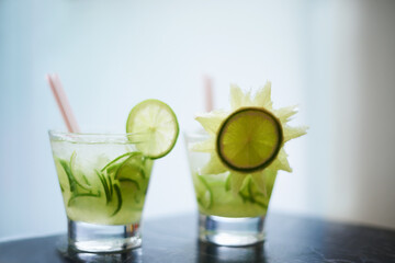 Keep cool this summer. Two beverages in glasses decorated with cucumbers.