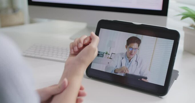 Asia people young woman worker work at home job video call telemedicine online clinic app for workforce care meet chat or tele consult to doctor remote advice teach to relax stiff neck or wrist pain.