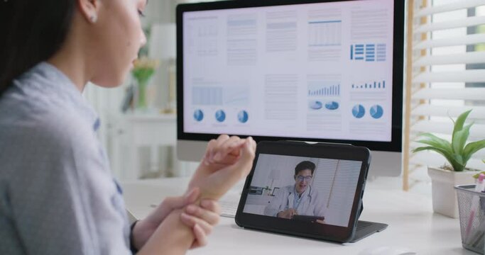 Asia people young woman worker work at home job video call telemedicine online clinic app for workforce care meet chat or tele consult to doctor remote advice teach to relax stiff neck or wrist pain.