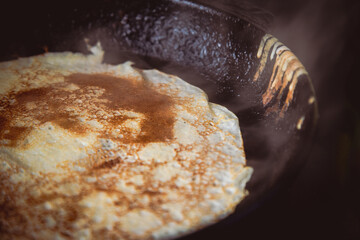 Homemade cakes. Pancakes are fried in a cast-iron frying pan