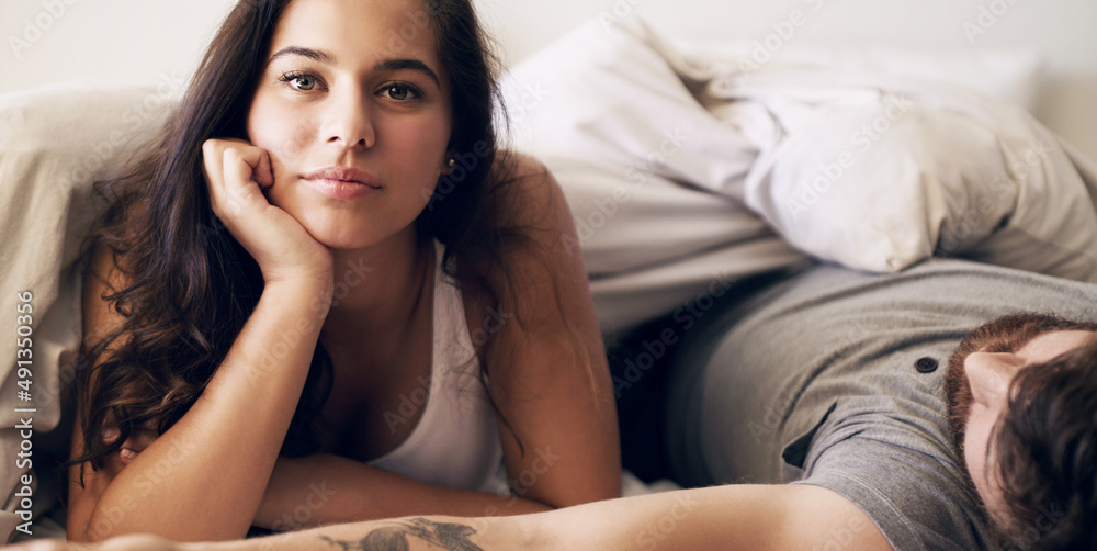 Poster Its a stay in bed with you kinda day. Shot of a young couple relaxing in bed together at home.