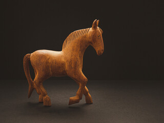 One old wooden horse over on the black background