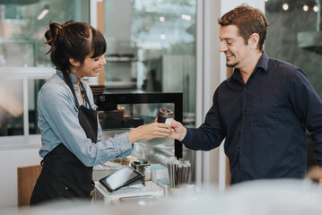 Caucasian woman barista giving takeout meal to customers. female barista working in coffee shop. Coffee owner concept.