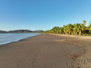 a sandy beach next to a body of water