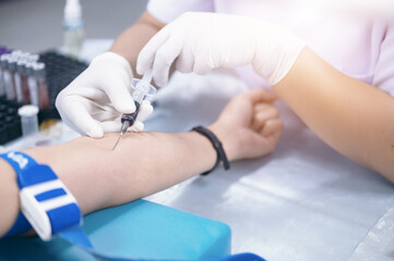 Close up hand of nurse, taking blood sample from a patient in the hospital.