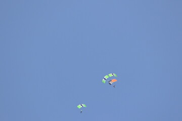 People Skydiving with a clear blue sky