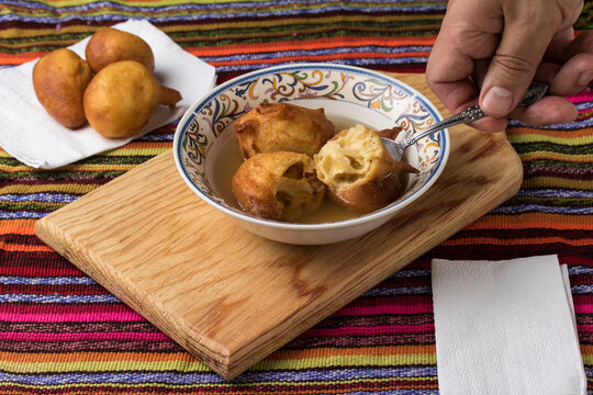 Partiendo los bue&ntilde;uelos guatemaltecos en plato con miel (almibar)