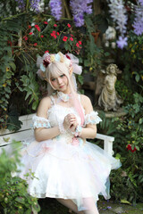 Fototapeta premium Beautiful young woman with white lolita dress with flowers garden Japanese fashion