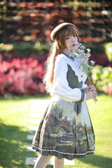 A beautiful woman in lolita dress in garden background Japanese street fashion portrait