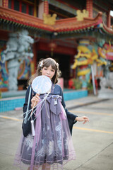 Beautiful young woman with dark blue Chinese lolita dress with Chinese garden