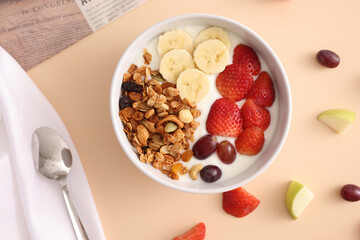 bowl of granola cereal with yogurt and berries isolated on eggnog color background