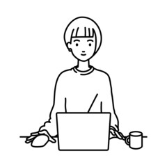 デスクで座ってPCを使っているリモートワークの女性