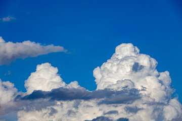 Naklejka premium thick white cummulus clouds on a sunny day against a bright blue sky. absorbent cotton clouds indicating bad weather. blue background on a sunny day. 
