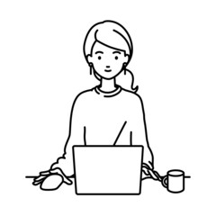 デスクで座ってPCを使っているリモートワークの女性