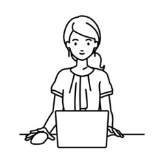 デスクで座ってPCを使っているオフィスカジュアルの女性