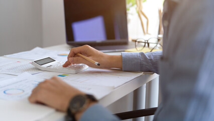 Male financial analysts using calculator, working on his financial work