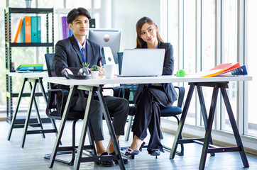 Asian young happy professional male businessman mentor and female businesswoman colleague in formal...