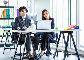 Asian young happy professional male businessman mentor and female businesswoman colleague in formal...