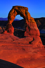 Twilight at the Delicate Arch and the distant La Sal Mountains, Arches National Park, Moab, Utah, USA