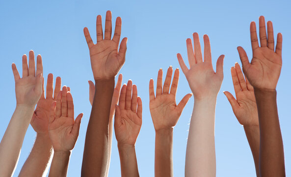 Solidarity through diversity. Cropped shot of a diverse group of people raising their hands.