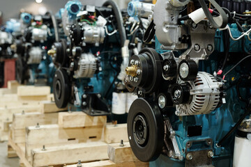 Row of motors of huge industrial machines with rotating shafts inside distribution warehouse of large contemporary plant